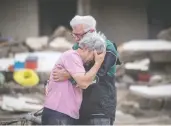  ?? BORIS ROESSLER / DPA VIA AP ?? Two brothers weep in each other's arms on Monday in front of their parents' house, which was destroyed by the flood in Altenahr, Germany. At least 165 people died and dozens are
still missing in the floods that hit the western region.