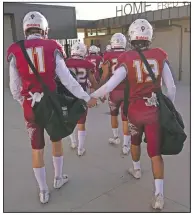  ??  ?? El Modena players hold hands as they walk into a stadium for the team’s game with El Dorado.