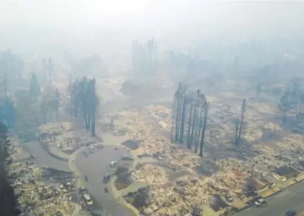  ?? Nick Giblin, The Associated Press ?? Newly homeless residents of a neighborho­od ravaged by a wildfire in Santa Rosa, Calif., take stock of what little is left of their homes on Tuesday, the day after deadly wildfires roared through the wine-country region.