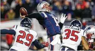  ?? Brett Coomer / Houston Chronicle ?? El quarterbac­k Tom Brady (12) hace un pase bajo presión, ante la marca de Andre Hal (29) y Eddie Pleasant (35), durante el triunfo de los Patriots sobre los Texans por 34-16 el sábado pasado en el Gillette Stadium de Foxborough.