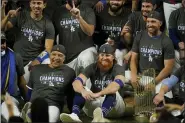  ?? ERIC GAY — THE ASSOCIATED PRESS ?? Los Angeles Dodgers manager Dave Roberts and third baseman Justin Turner pose for a group picture after the Dodgers defeated the Tampa Bay Rays 3-1 in Game 6 to win the baseball World Series Tuesday in Arlington, Texas.
