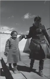  ??  ?? Jampal Thobthen helps a physically impaired boy to walk on the balancing board at the kindergart­en.