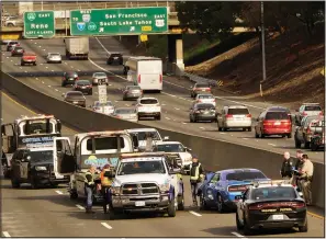  ?? (File Photo/AP/Rich Pedroncell­i) ?? A police officer riding a motorcycle was killed Jan. 21, 2022, after being struck by a man driving the blue car the wrong way on southbound Highway 99 in Sacramento, Calif.