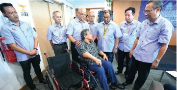  ??  ?? Aseh (third right) speaks to an employee who was recently injured. Phillip is at right.