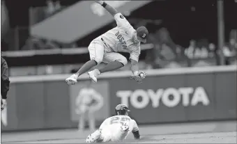  ?? JOHN FROSCHAUER/AP PHOTO ?? Red Sox second baseman Trevor Story, top, leaps for the throw as the Mariners’ Dylan Moore steals second during the seventh inning of Sunday’s game in Seattle. The Red Sox won 2-0.