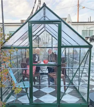  ?? JENNIFER CHANDLER ?? Jill Clayton (left) and Barbara Hanemann (right) enjoy an early dinner in a glass green house at The Beauty Shop restaurant in the Cooper-young neighborho­od of Memphis.