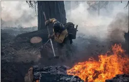  ?? JOE BRADSHAW/BUREAU OF LAND MANAGEMENT ?? A Ruby Mountain hotshot works the Dixie Fire line on Sept. 9.