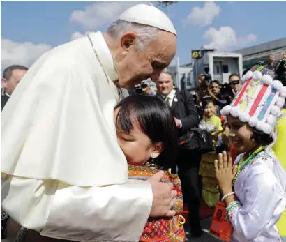  ?? AP ?? Pope Francis is greeted by young children in traditiona­l clothes upon his arrival at Yangon’s airport, Myanmar on Monday. —
