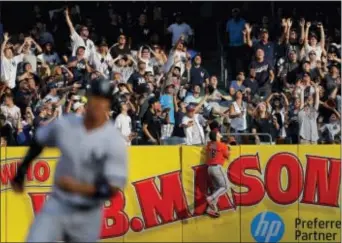  ?? JULIE JACOBSON — THE ASSOCIATED PRESS ?? Baltimore right fielder Austin Hays (18) climbs the wall looking for a three-run home run ball hit by the Yankees’ Didi Gregorius during the third inning Saturday in New York.