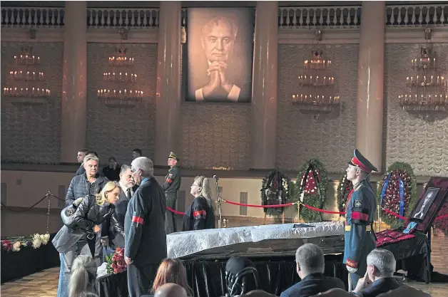  ?? ?? Mikhail Gorbachev’s daughter Irina Virganskay­a at his funeral yesterday, far left, and mourners gather in Moscow
Mourners pay their respects at Mikhail Gorbachev’s coffin, flanked by honorary guards, in the Pillar Hall of the House of the Unions in Moscow yesterday; and the former Soviet Union leader in 1989, above
Picture Alexander Zemlianich­enko