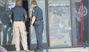  ?? AP PHOTO ?? Investigat­ors enter the Armed Forces Career Center through a bullet-riddled door after a gunman opened fire on the building Thursday in Chattanoog­a, Tenn.