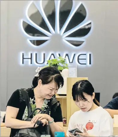  ?? QILAI SHEN / BLOOMBERG ?? Una empleada atiende a una clienta en una tienda de Huawei en la ciudad china de Shenzhen
