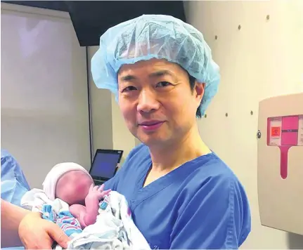  ?? Courtesy New Hope Fertility Centre ?? Dr John Zhang with the world’s first baby born using DNA from three people.