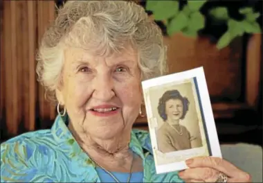  ?? MICHAEL CONROY/ AP PHOTOS ?? Laura Mae Davis Burlingame, 90, holds a photo of herself from high school, in her Moorsevill­e, Ind. home. The photo filled the back cover of a diary she had given to a Marine Cpl. Thomas “Cotton” Jones, a 22- year- old machine gunner, who died in the...