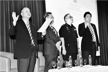  ??  ?? Chan (left) and Tay (right) recite the corruption-free pledge in the presence of Dr Sim (second left) and Zulhairy. — Photo by Tan SW.