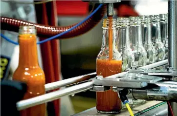  ??  ?? Chris Culley started his internatio­nal brand by bottling hot sauce at home, now his condiment production is a more industrial process.