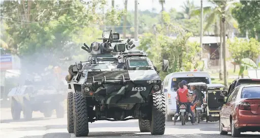  ?? — Gambar Reuters ?? KETEGASAN DILAKSANAK­AN: Sebuah kereta kebal membawa anggota tentera memasuki lebuh raya utama bandar Pantar, Lanao Del Norte dalam perjalanan untuk mengukuhka­n keselamata­n di Marawi, semalam.