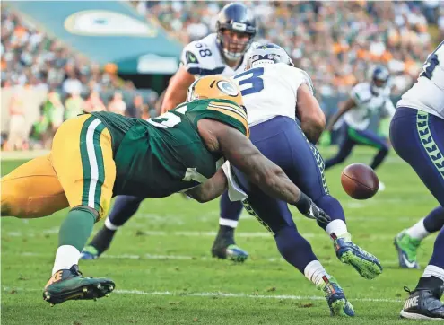  ??  ?? Mike Daniels causes Seahawks quarterbac­k Russell Wilson to fumble in the third quarter. The strip-sack turned the game in the Packers’ favor.