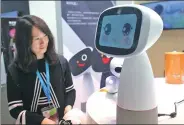  ?? CHEN YUYU / FOR CHINA DAILY ?? A visitor interacts with a robot at a high-tech exhibition in Shanghai.