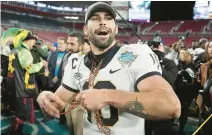  ?? CHRIS OMEARA/AP ?? Wake Forest quarterbac­k Sam Hartman throws beads to his teammates after being named the Most Valuable Player of the Gasparilla Bowl on Friday in Tampa, Florida.