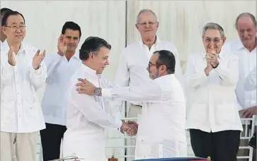  ?? Fernando Vergara Associated Press ?? COLOMBIAN President Juan Manuel Santos, center left, and FARC commander Rodrigo Londoño shake in Cartagena after signing the peace deal. Behind them are U.N. leader Ban Ki-moon, Presidents Enrique Peña Nieto of Mexico, Pedro Pablo Kuczynski of Peru and...