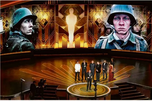  ?? Foto: Chris Pizzello/invision/ap ?? Regisseur Edward Berger (vorne) nimmt den Preis für „Im Westen nichts Neues“aus Deutschlan­d für den besten internatio­nalen Spielfilm bei der Oscar-verleihung im Dolby Theatre in Los Angeles entgegen.