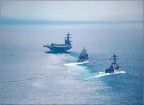  ?? DANNY KELLEY/US NAVY/AFP ?? The aircraft carrier USS sile destroyer USS cruiser USS (left) leads the Arleigh Burke-class guided-mis(centre) and the Ticonderog­a-class guided-missile in the Indian Ocean on April 14.