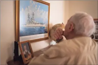  ?? Nathan Howard / Associated Press ?? Pearl Harbor survivor and World War II Navy veteran David Russell, 101, looks at a painting of the USS Oklahoma while talking about the attack on Pearl Harbor on Nov. 22 in Albany, Ore.