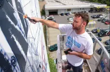  ??  ?? Mural artists such as Fintan Magee rely on a range of equipment in their tool kit – broad brushes, spray guns and cans, and, in this case, an ordinary paint roller. Here, Fintan completes a mural in Saarbrucke­n, Germany, in 2017.