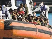  ?? ALESSANDRA TARANTINO AP FILE ?? Rescued migrants and refugees enter in the port of Roccella Jonica in southern Italy on Nov. 14.