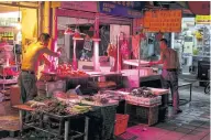  ??  ?? LEFT
Men work in a market in the Yuexiu neighbourh­ood.