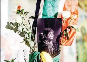  ?? RAJESH JANTILAL/AFP ?? A black and white photograph of the late Winnie Madikizela-Mandela is surrounded by the South African and African National Congress flags on a pole as South Africans gather to pay respect to the late high-profile anti-apartheid activist during a candle...