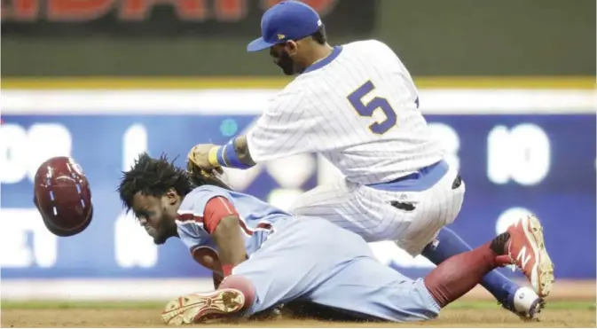  ??  ?? MILWAUKEE: Philadelph­ia Phillies’ Odubel Herrera is safe at second with a double as Milwaukee Brewers’ Jonathan Villar applies a late stage during the ninth inning of a baseball game Saturday, in Milwaukee. —AP