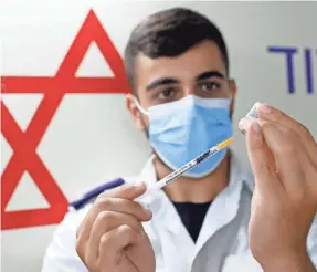  ?? AFP VIA GETTY IMAGES ?? An Israeli medical worker prepares a dose of the Pfizer vaccine during a campaign to encourage the vaccinatio­n of teens in Tel Aviv.
