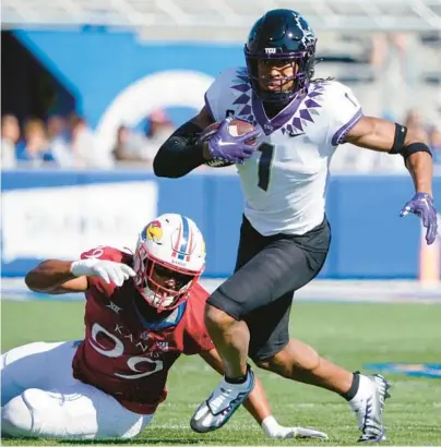  ?? ED ZURGA/GETTY ?? TCU wide receiver Quentin Johnston (1) gets past Kansas defensive lineman Malcolm Lee in Saturday’s game at David Booth Kansas Memorial Stadium in Lawrence, Kansas.