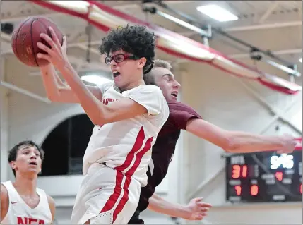  ?? TIM MARTIN/THE DAY ?? Mason Jackson, center, of NFA, grabs a rebound against East Lyme’s Jacob Peters during Tuesday’s ECC Division I game in Norwich.