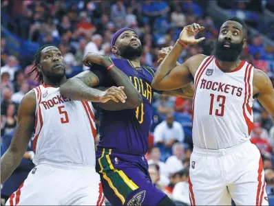  ?? JONATHAN BACHMAN / AFP ?? DeMarcus Cousins of the New Orleans Pelicans is sandwiched by Houston Rockets’ Montrezl Harrell (left) and James Harden during the first half of Thursday’s game at the Smoothie King Center in New Orleans, Louisiana. Houston won 129-99.