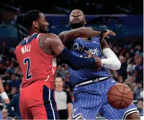  ?? JOHN RAOUX/AP ?? Orlando Magic forward Jonathon Simmons, right, loses control of the ball as he goes to the basket against Washington Wizards guard John Wall (2) during the second half Friday in Orlando, Fla.