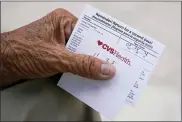  ?? WILFREDO LEE - THE ASSOCIATED PRESS ?? In this May 3 file photo, a man holds his vaccinatio­n reminder card after having received his first shot at a pop-up vaccinatio­n site in the Little Havana neighborho­od of Miami. Billions more in profits are at stake for some vaccine makers as the U.S. moves toward dispensing COVID-19booster shots to shore up Americans’ protection against the virus. Drugstore chains CVS Health and Walgreens could bring in more than $800 million each in revenue, according to Jeff Jonas, a portfolio manager with Gabelli Funds.