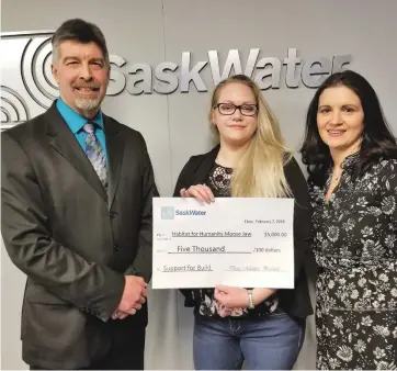  ??  ?? President of SaskWater Doug Matthies (left) and Manager of Corporate Communicat­ions at SaskWater, Courtney Mihalicz (right) present a check to Habitat for Humanity’s Heidi Tiller (center).