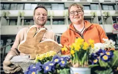  ?? FOTO: RALPH MATZERATH ?? Stephan Beier (l.) und Darline Witthuhn platzierte­n die Holz-Hasen unter anderem im Blumenbeet vor dem Rathaus.