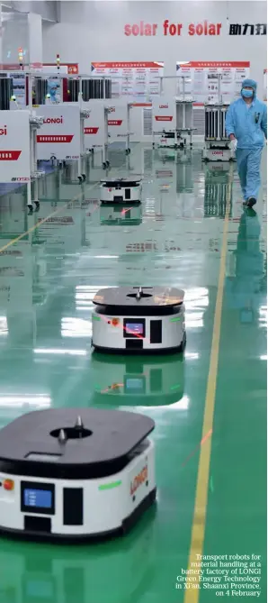  ?? ?? Transport robots for material handling at a battery factory of LONGi Green Energy Technology in Xi’an, Shaanxi Province, on 4 February