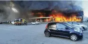  ?? UKRAINIAN STATE EMERGENCY SERVICE VIA AP ?? Firefighte­rs work to extinguish a fire at a shopping center burned after a rocket attack in Kremenchuk, Ukraine, Monday.