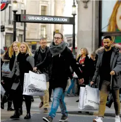  ?? (Darrin Zammit Lupi/Reuters) ?? SHOPPERS CROSS the street at Oxford Circus in London yesterday.