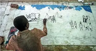  ?? AFP ?? A protester paints a mural outside the army headquarte­rs in Khartoum on Sunday. —