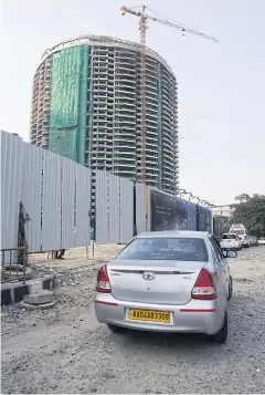  ?? BLOOMBERG ?? Vehicles sit parked as a crane stands at a constructi­on site in Bengaluru on Oct 20, 2017.