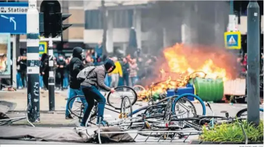  ?? ROB ENGELAAR / EFE ?? Manifestan­tes contra las restriccio­nes por el coronaviru­s destrozan bicicletas ayer en Eindhoven.