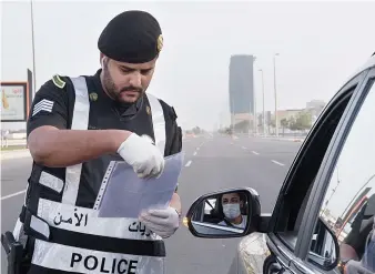  ?? SPA ?? Police enforcing the curfew order check motorists along a road in Jeddah on Sunday.