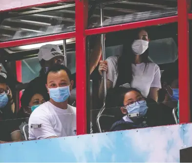  ?? ANTHONY WALLACE / AFP VIA GETTY IMAGES ?? Commuters travel on a tram in Hong Kong on Friday. Democracy lawmaker Au Lok-hin said he believed the raid on the Hong Kong Public Opinion Research Institute was related to primary elections slated for this weekend.