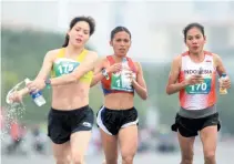  ?? JEROME ASCANO ?? CHRISTINE HALLASGO (center) placed second in marathon.